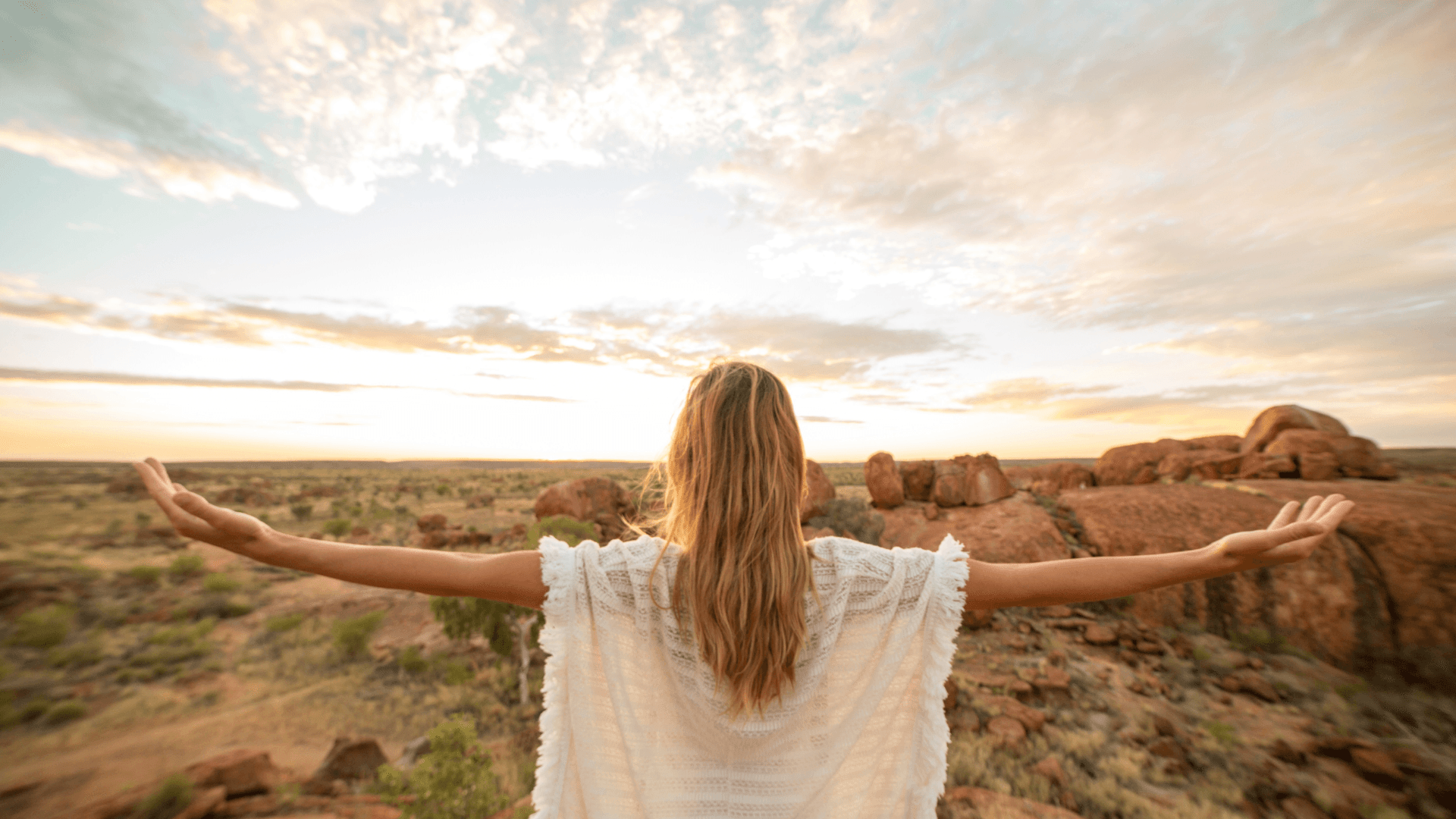 Woman with arms outstretched across the Australian outback — a Downscale confidence journey